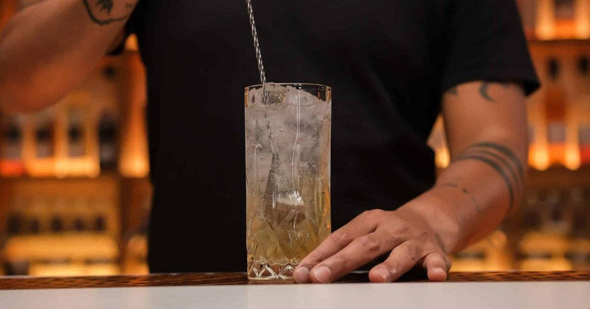 ขั้นตอนการชง Highball แบบญี่ปุ่น: เทวิสกี้ลงบนน้ำแข็งก้อนใหญ่ในแก้วทรงสูง ก่อนเติมโซดาเย็นจัดอย่างนุ่มนวล