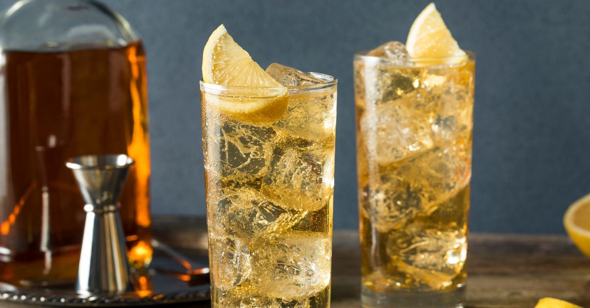 แก้ว Highball ทรงสูงเต็มน้ำแข็งก้อนใหญ่ วิสกี้ญี่ปุ่นสีทองใสกับฟองโซดาเปล่งประกาย มีเปลือกมะนาววางพาดบนปากแก้ว