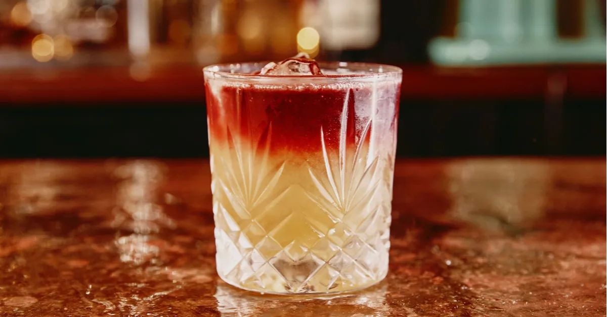 New York Sour ที่ลอยไวน์แดงเป็นชั้นสีทับทิมบนผิว เทียบกับ Boston Sour ที่มีฟองไข่ขาวนุ่ม